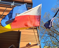 Znacznik Totupoint przed budynkiem C. nad znacznikeim są widoczne trzy flagi: polska, ukraińska i unijna
