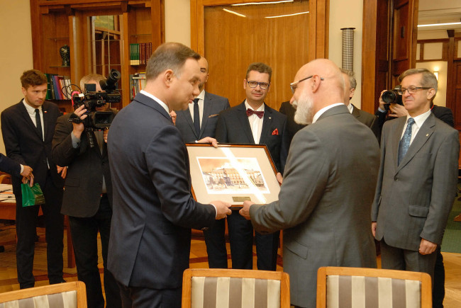 Prezydent RP Andrzej Duda przekazuje pamiątkowy upominek rektorowi prof. Markowi Rockiemu