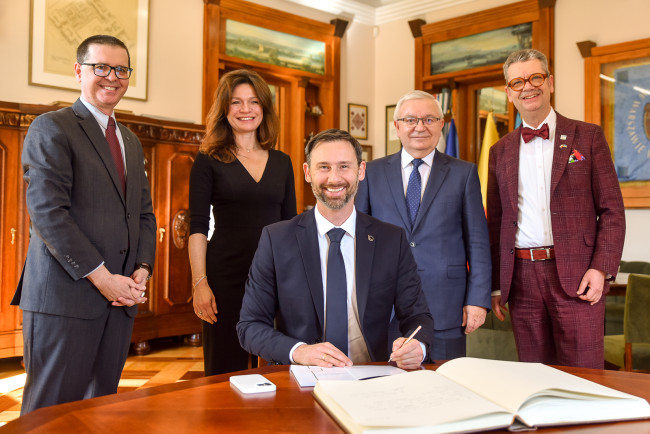 Dr. inż. Sławosz Uznański‑Wiśniewski dokonuje wpisu do Księgi pamiątkowej SGH
