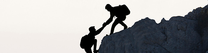 dwie osoby współpracujące podczas wspinaczki górskiej