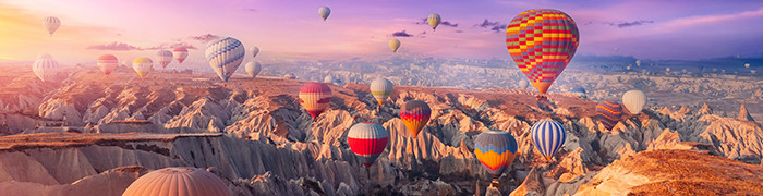 Balony lecace nad górami o wschodzie słońca