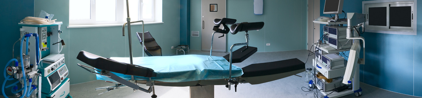 pusta sala operacyjna z łóżkiem na środku i aparaturą medyczną zdjęcie