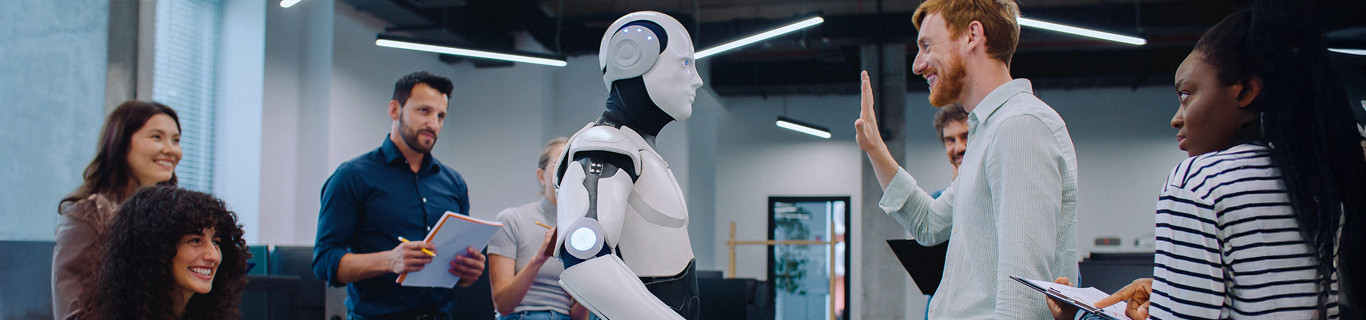 Grupa uśmiechniętych pracowników biurowych podczas spotkania z humanoidalnym robotem