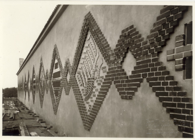 Budynek Biblioteki Wyższej Szkoły Handlowej, obrazy na attyce z polewanych, kolorowych cegieł, 1930 rok