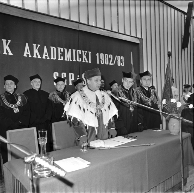 Inauguracja roku akademickiego 1982/1983  W pierwszym rzędzie od lewej profesorowie: Stanisław Nowacki – rektor, Wojciech Wrzosek – prorektor, Jerzy Z. Holzer – prorektor, w drugim rzędzie: Michał Kolupa – dziekan Wydziału Finansów i Statystyki, Zbigniew Pirożyński – przedstawiciel Wydziału Finansów i Statystyki, Bogdan Kołodziejek – dziekan Wydziału Handlu Wewnętrznego