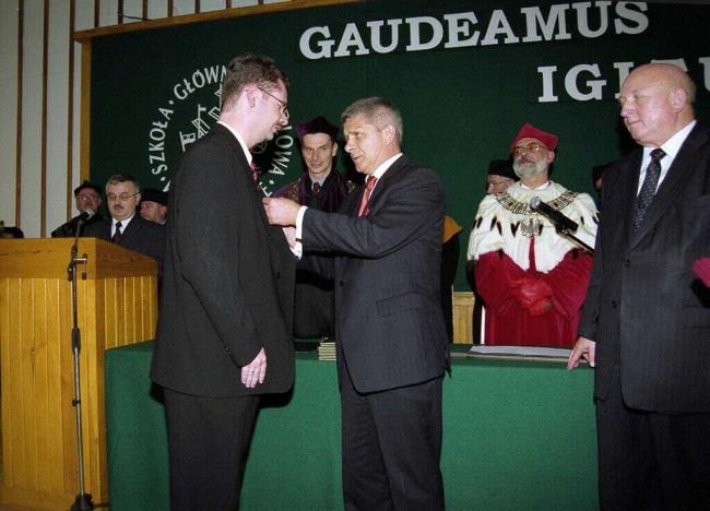 Inauguracja roku akademickiego 2004/2005. Nagrodę państwową odbiera dr Piotr Wachowiak. Nagrodę wręcza Marek Belka – prezes Rady Ministrów