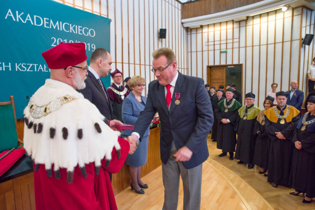 Inauguracja roku akademickiego 2018/2019  Dr Piotr Maszczyk odbiera Brązowy Krzyż Zasługi. Gratulacje składa rektor prof. Marek Rocki ​  