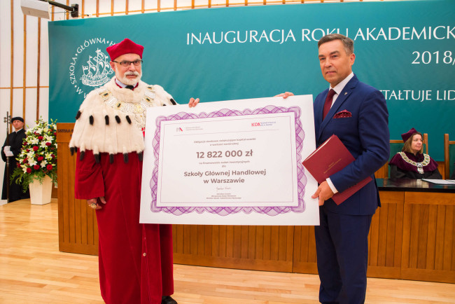 Inauguracja roku akademickiego 2018/2019​. Poseł Zbigniew Gryglas wręcza rektorowi prof. Markowi Rockiemu symboliczne obligacje skarbowe na finansowanie zadań inwestycyjnych w kwocie 12 822 000 zł