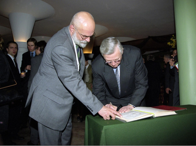 Prof. Ronald W. Jones i prof. Marek Rocki. Prof. W. Jones wpisuje się do księgi pamiątkowej 