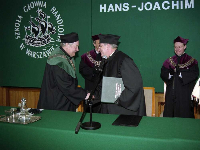 Uroczystość nadania tytułu doktora honoris causa SGH profesorowi Hansowi-Joachimowi Paffenholzowi. Gratulacje składa prof. Romuald Bauer, dziekan Kolegium Zarządzania i Finansów