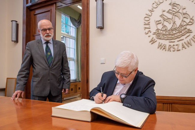 Uroczystość nadania tytułu doktora honoris causa SGH profesorowi Jerzemu Hausnerowi. Prof. Jerzy Hausner wpisuje się do księgi pamiątkowej SGH 