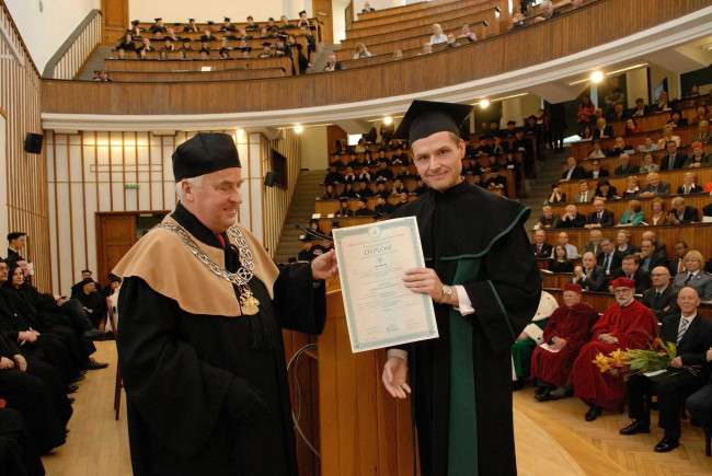 Święto SGH, 15 kwietnia 2015 roku, prof. Adam Budnikowski, dziekan Kolegium Gospodarki Światowej wręcza dyplom doktorski dr. Piotrowi Buzale