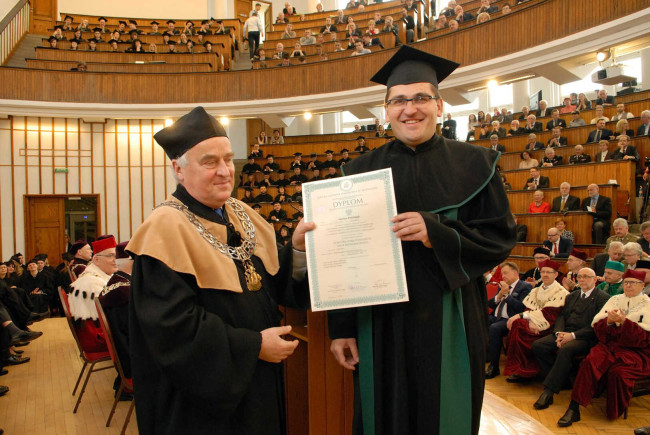 Święto SGH, 13 kwietnia 2016 roku. Prof. Adam Budnikowski, dziekan Kolegium Gospodarki Światowej​ ​wręcza dyplom doktora habilitowanego dr hab. Mariuszowi Próchniakowi