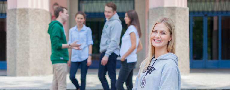 grupa studentów przed wejściem do budynku głównego SGH